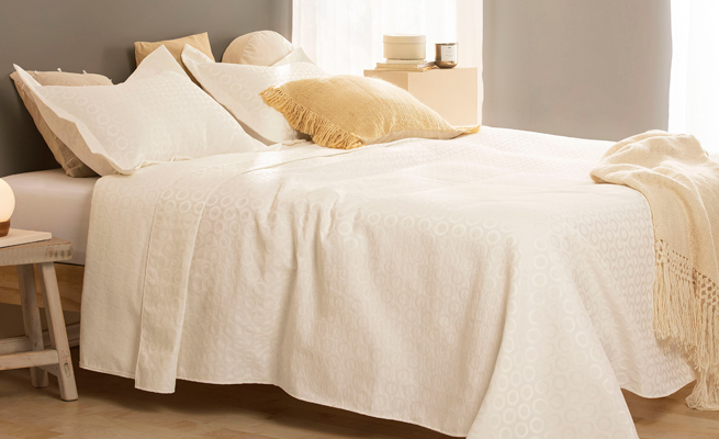 cama con cubrecamas y almohadas